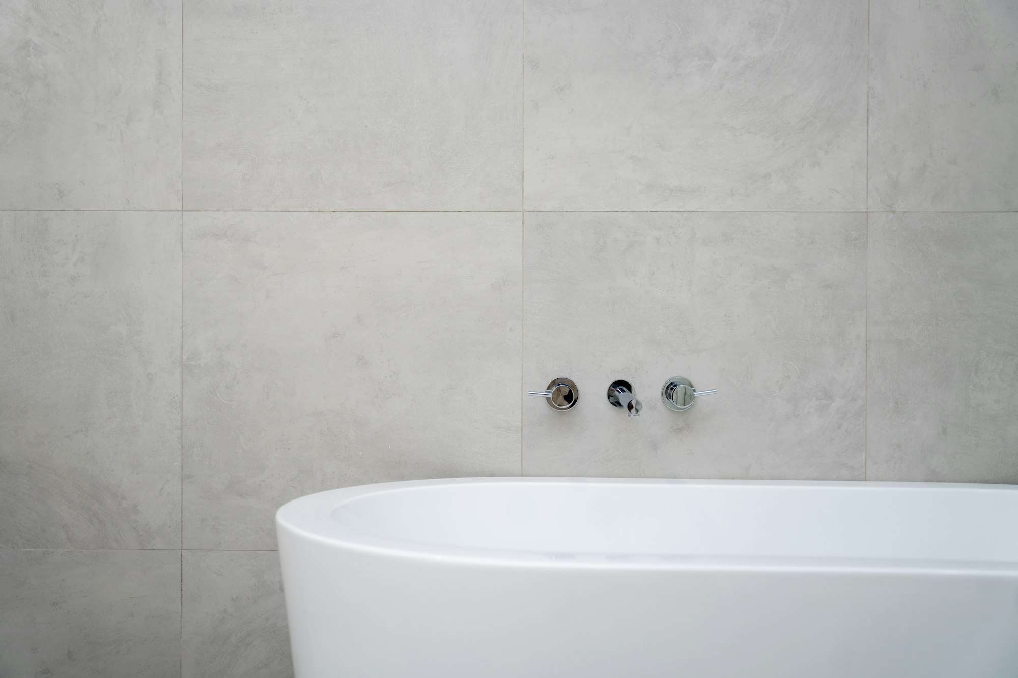Baignoire îlot devant un mur de grès gris