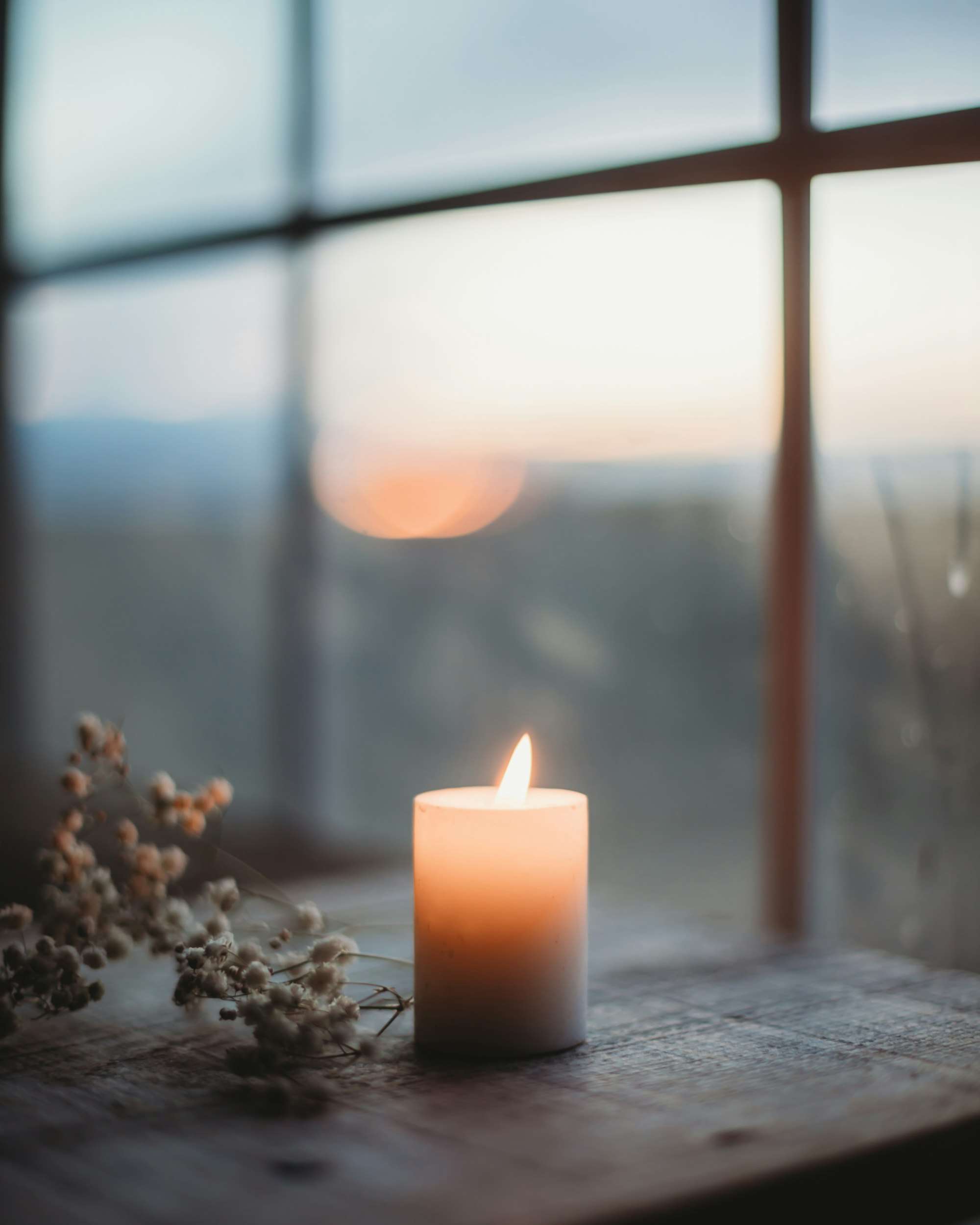 Bougie allumée sur un rebord de fenêtre au crépuscule