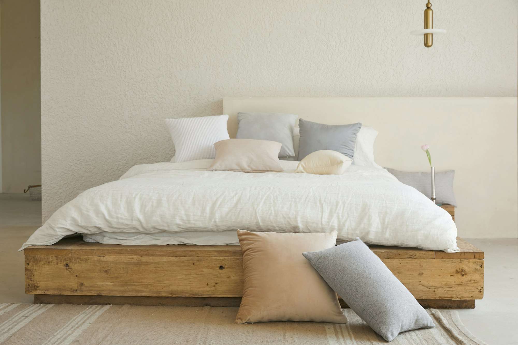 Chambre au lit bas en bois brut et au linge blanc