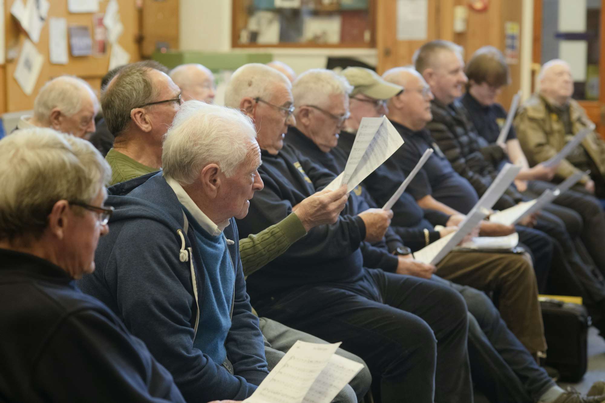 Des hommes âgés lisent leurs paroles pendant une répétition