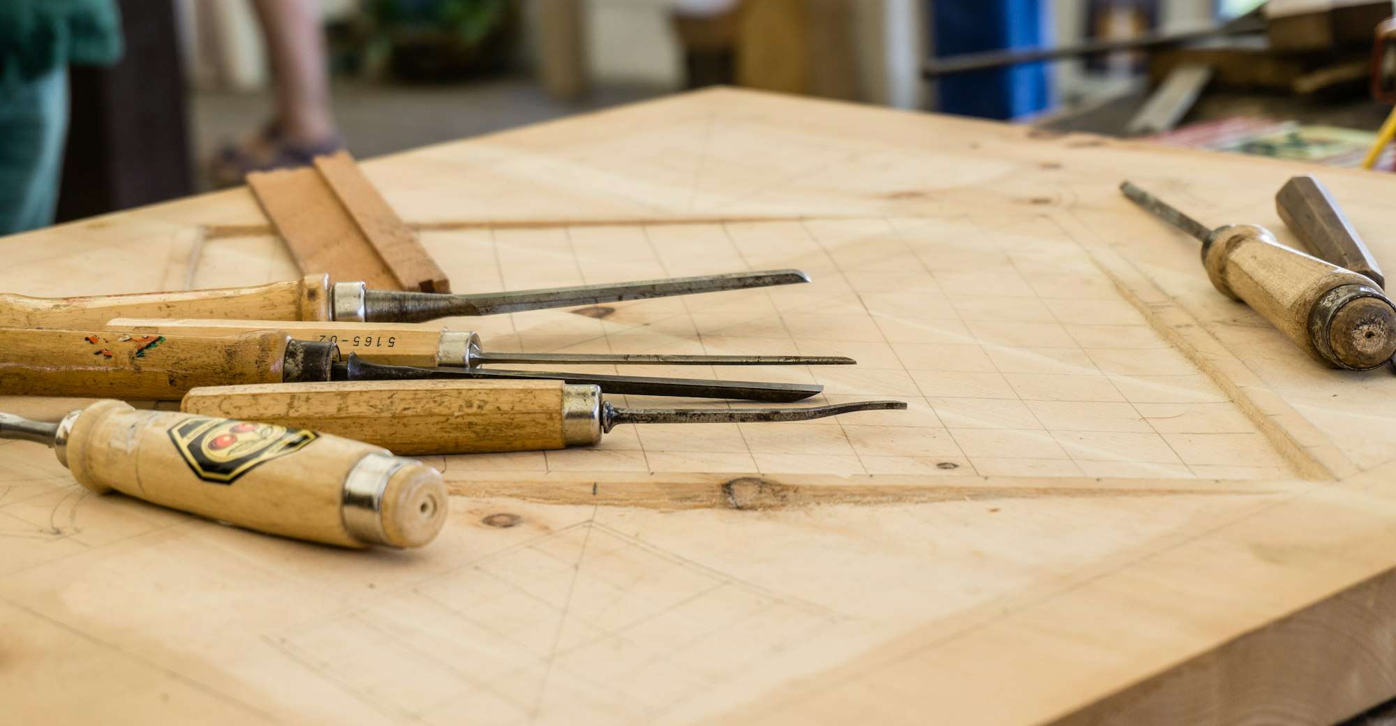 Ciseaux à bois posés sur un plateau tracé