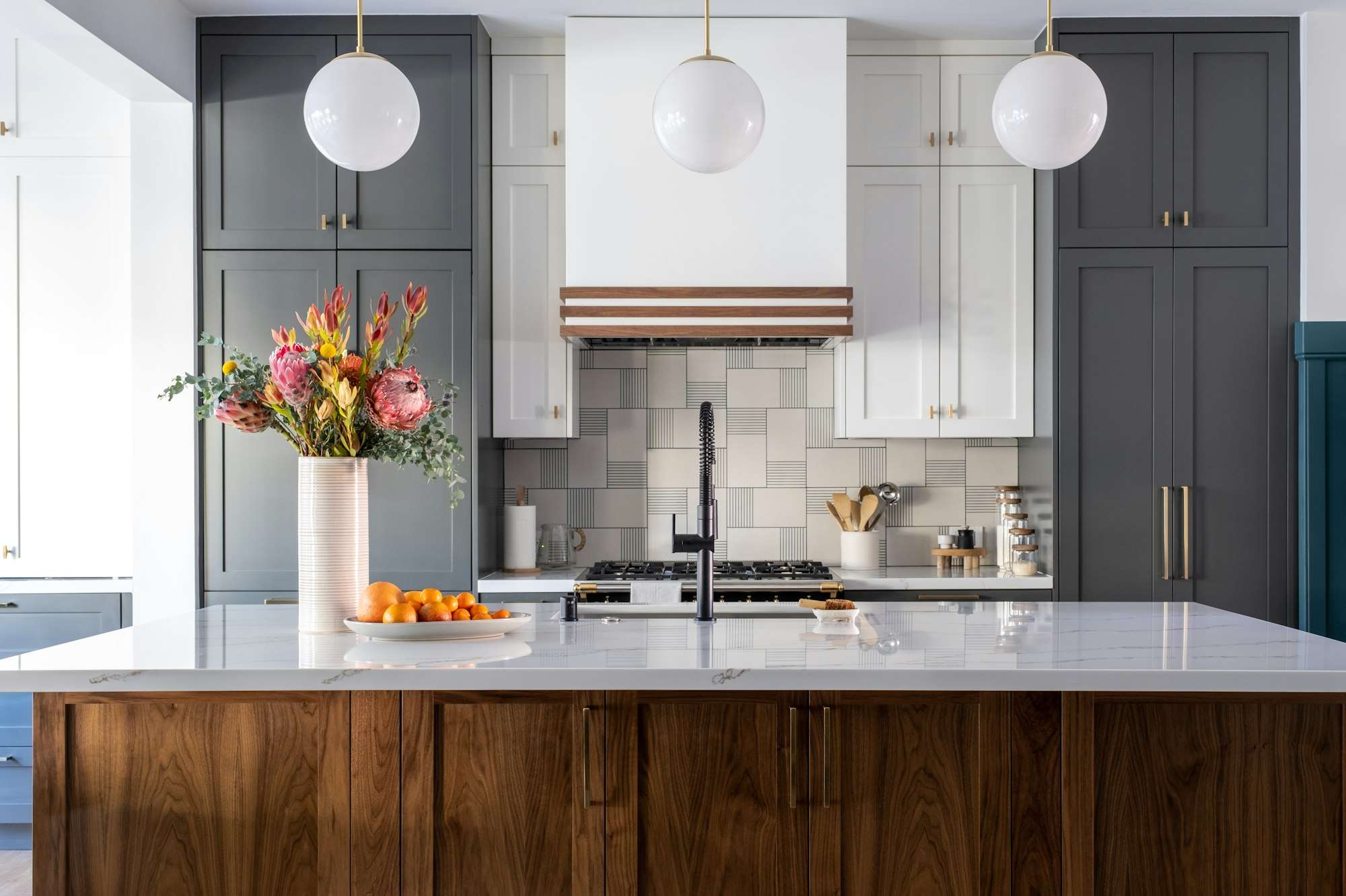 Cuisine rénovée, îlot en bois foncé et plan de travail en marbre clair