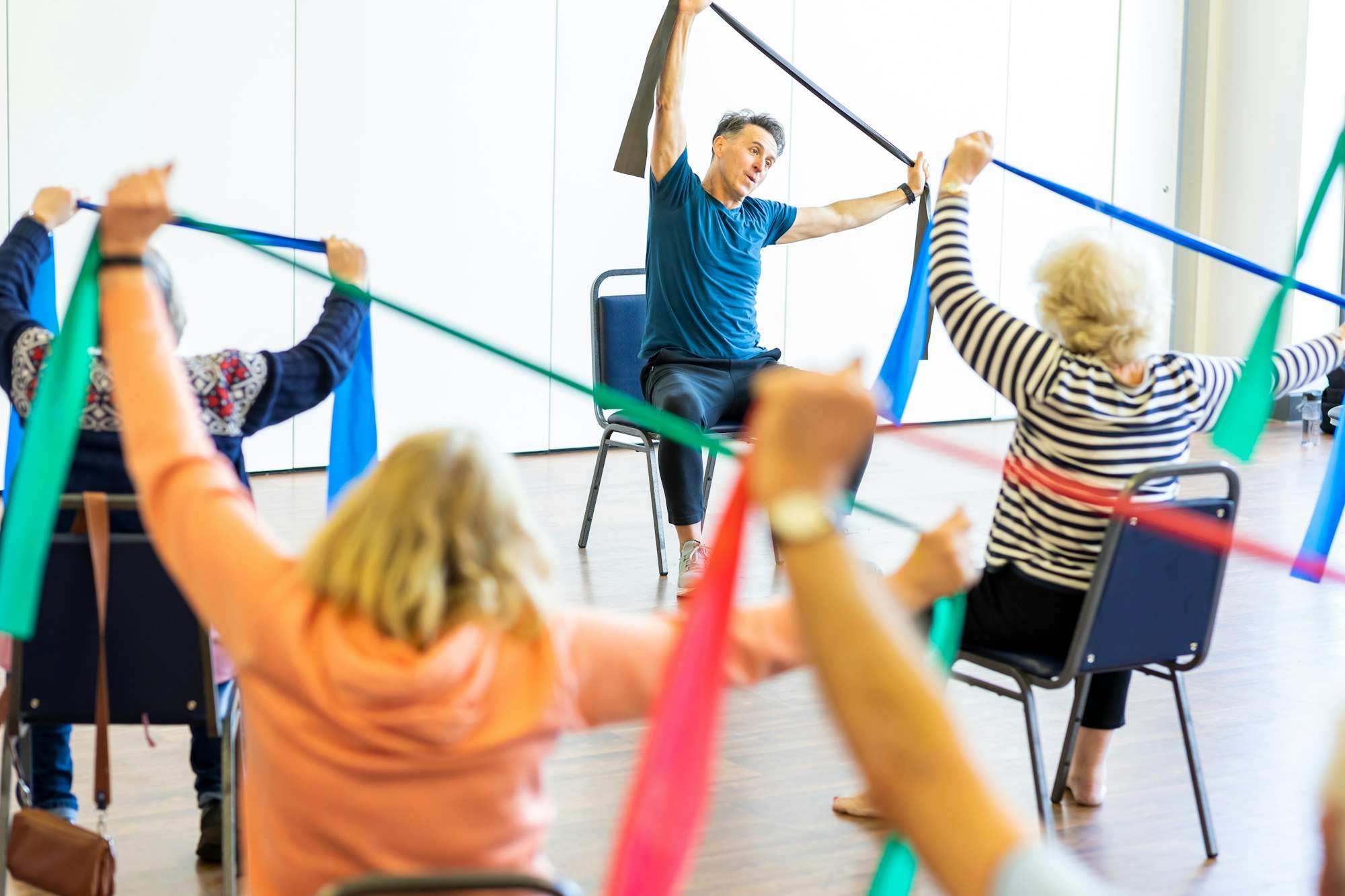 Des participants s’étirent avec des bandes élastiques de couleur