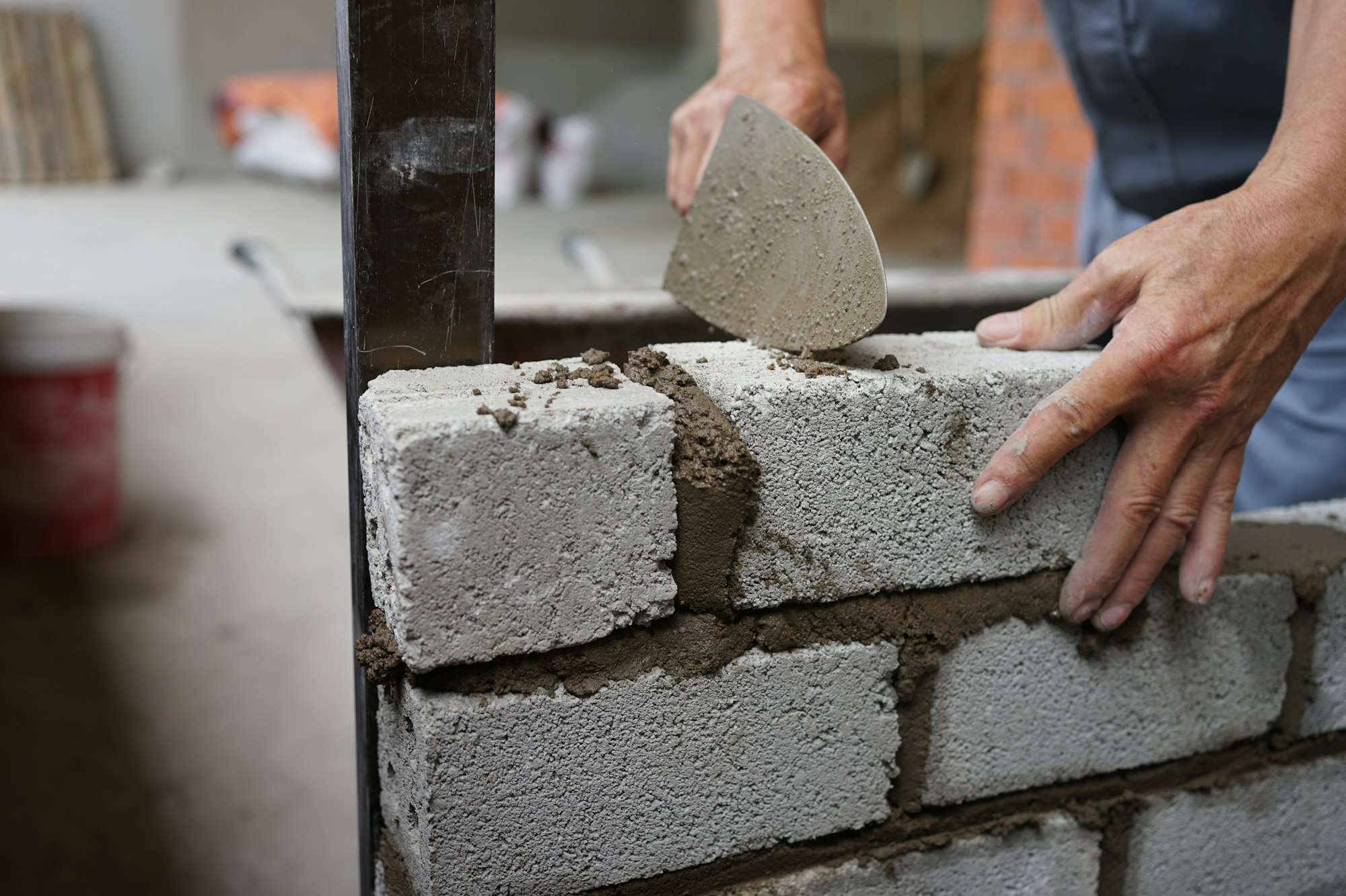Pose d’un bloc de béton sur un lit de mortier