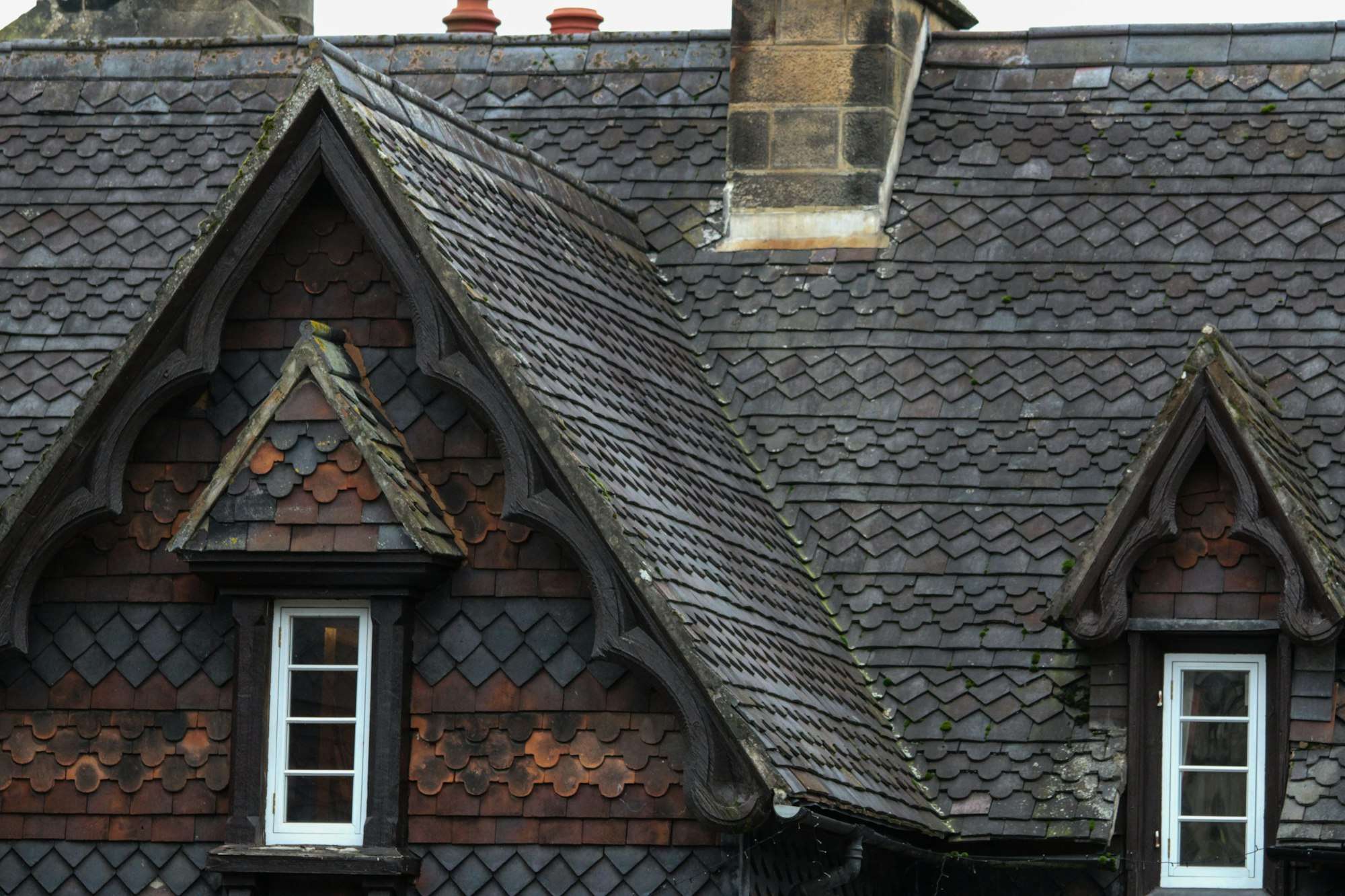 Toit d’ardoise d’une maison ancienne avec deux lucarnes