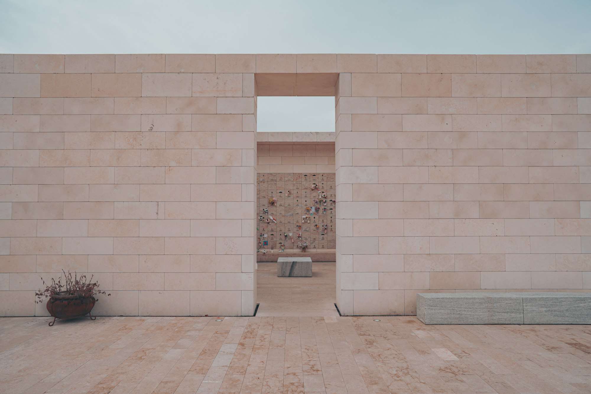 Passage ouvert dans un long mur de pierre claire