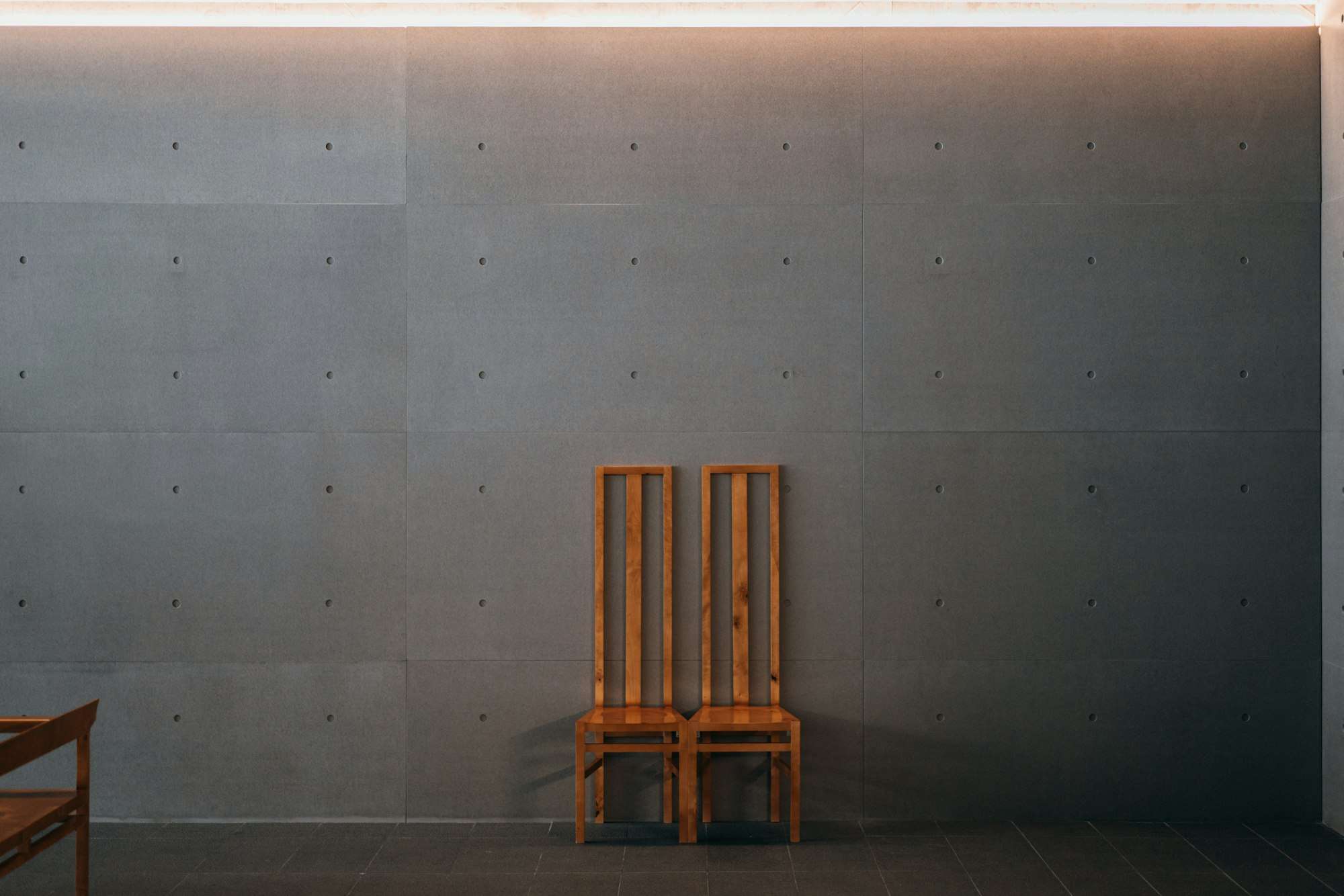 Fauteuil en bois dans une alcôve de béton