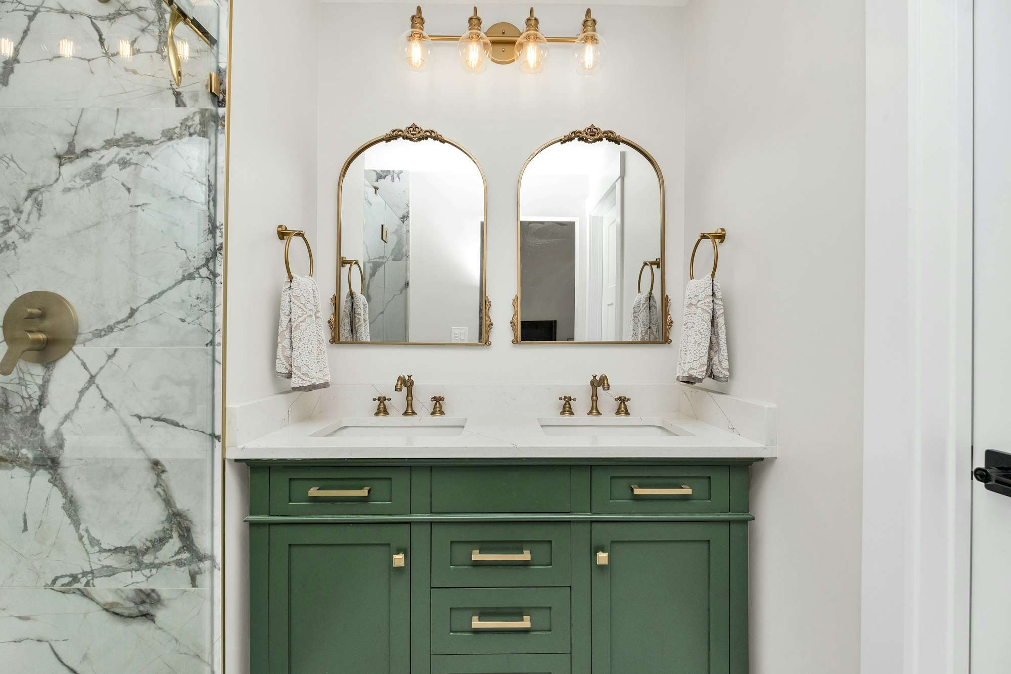 Salle de bain rénovée avec meuble vasque vert et marbre clair