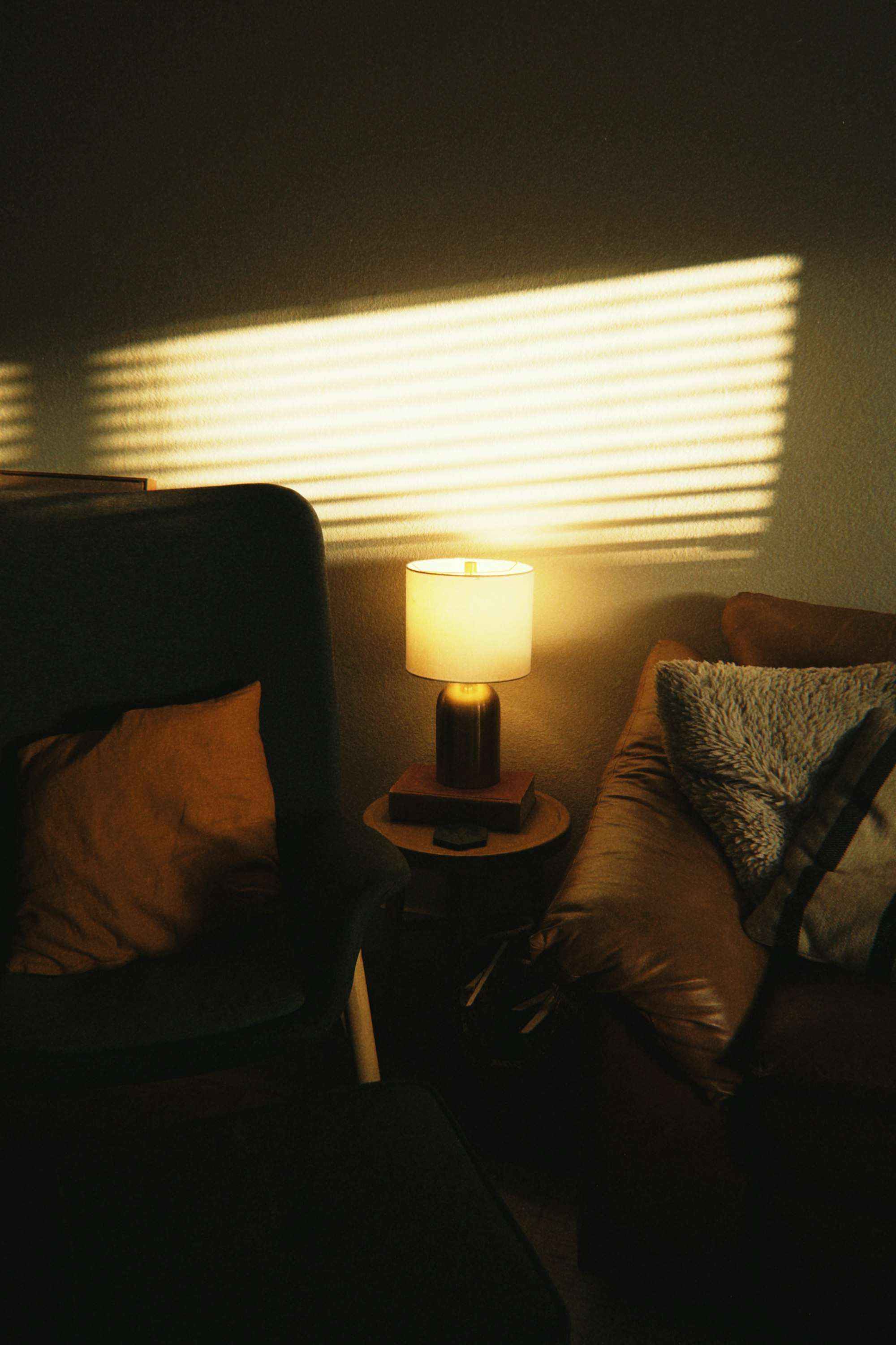 Coin de salon le soir, une petite lampe allumée entre deux fauteuils