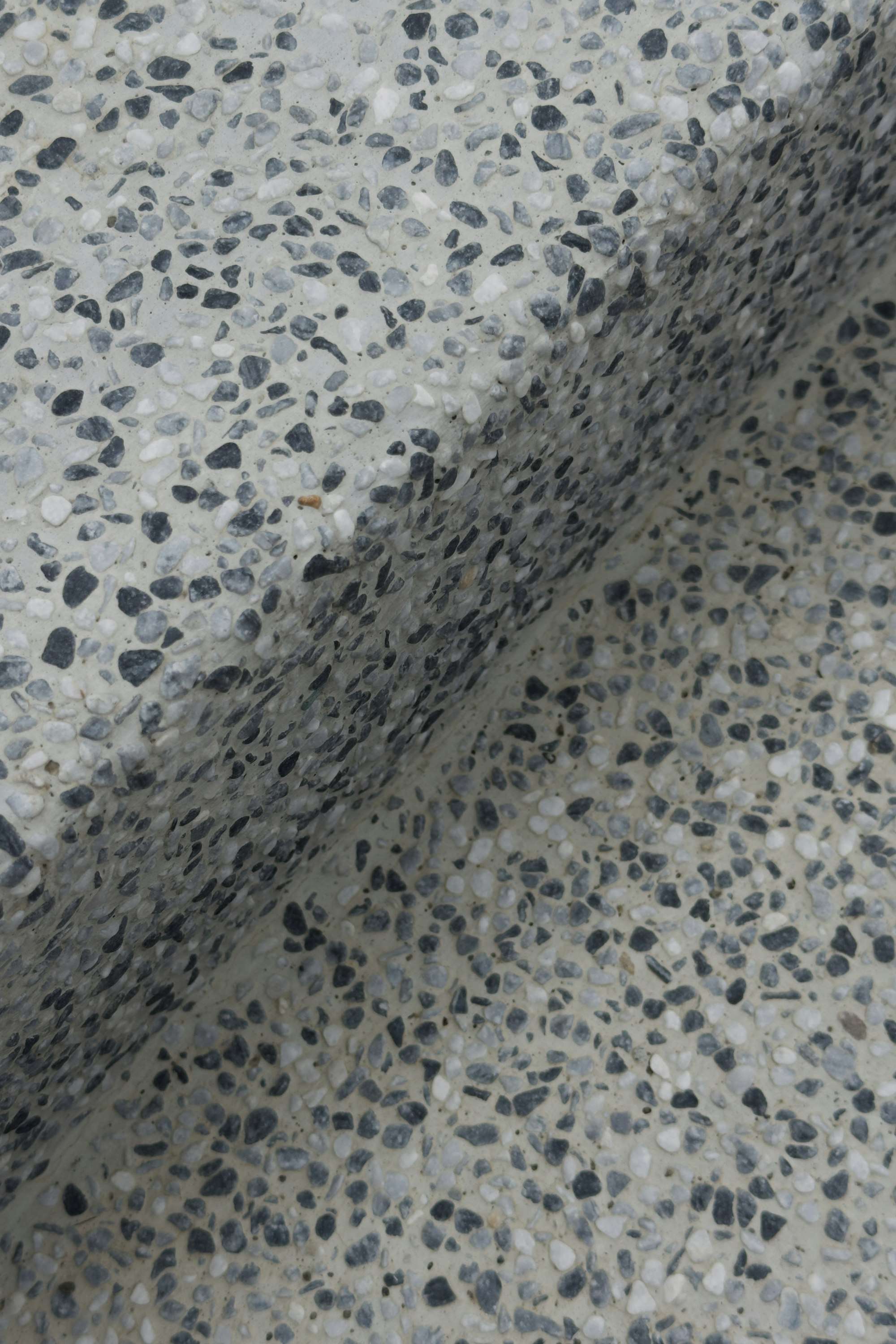 Détail d’un sol en terrazzo aux granulats clairs et sombres