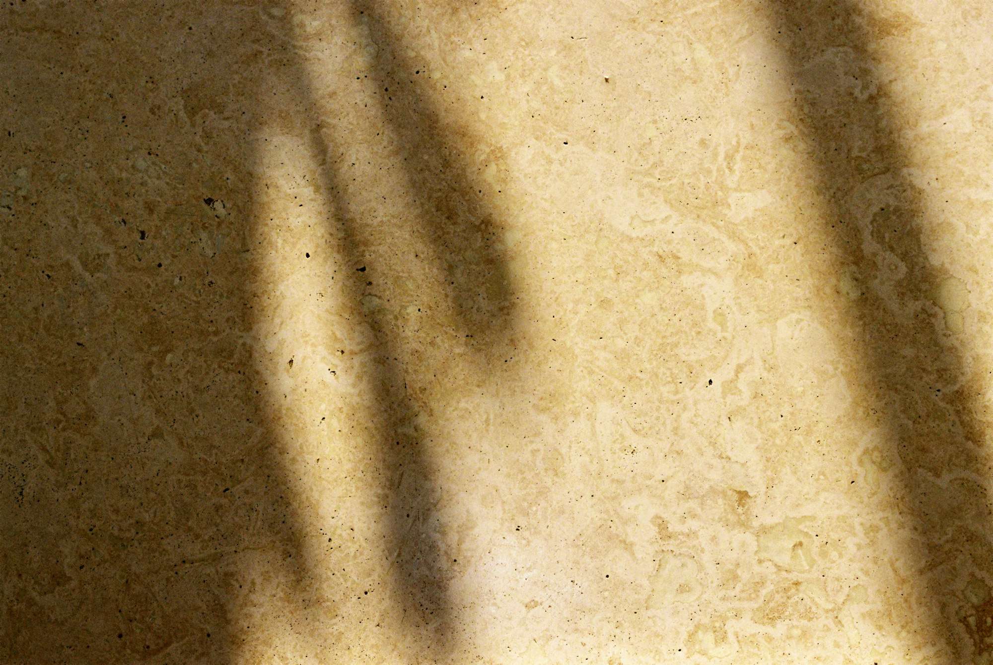Surface de travertin veiné sous une ombre portée