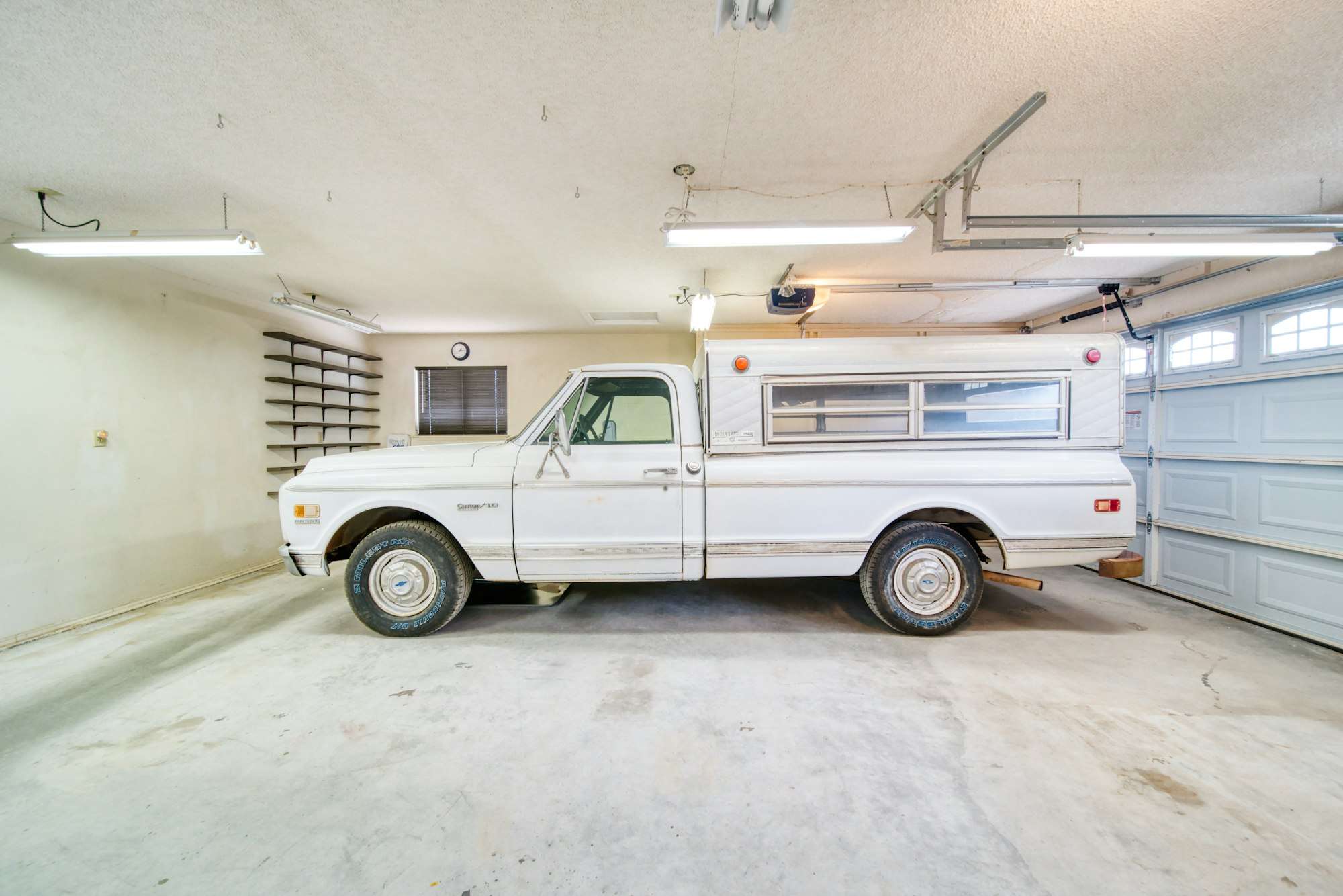 Pick-up ancien blanc garé dans un garage clair
